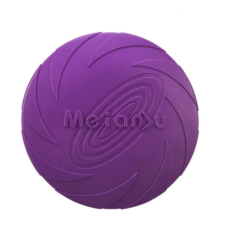 A dog catching a blue flying disc with more discs in orange and purple lying on the ground.