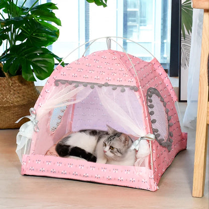 Pink pet tent with a cat inside, placed on a wooden floor with a plant in the background.